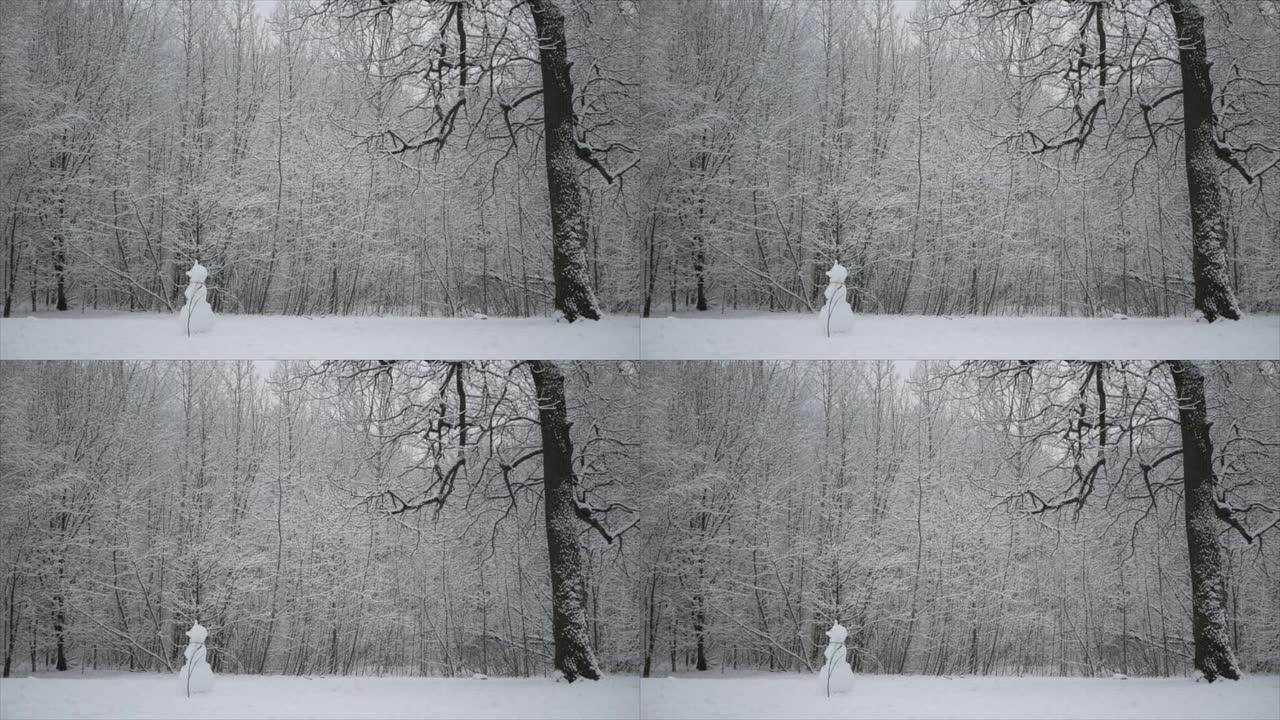 冬天的森林里正在下雪。雪人站在森林林间空地上。
