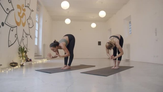 慢动作视频的两个女人练瑜伽，乌鸦或bakasana姿势