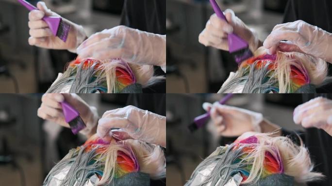 美发师调色师用刷子在头发上涂上油漆。短发，剃光太阳穴，装饰在头发上。