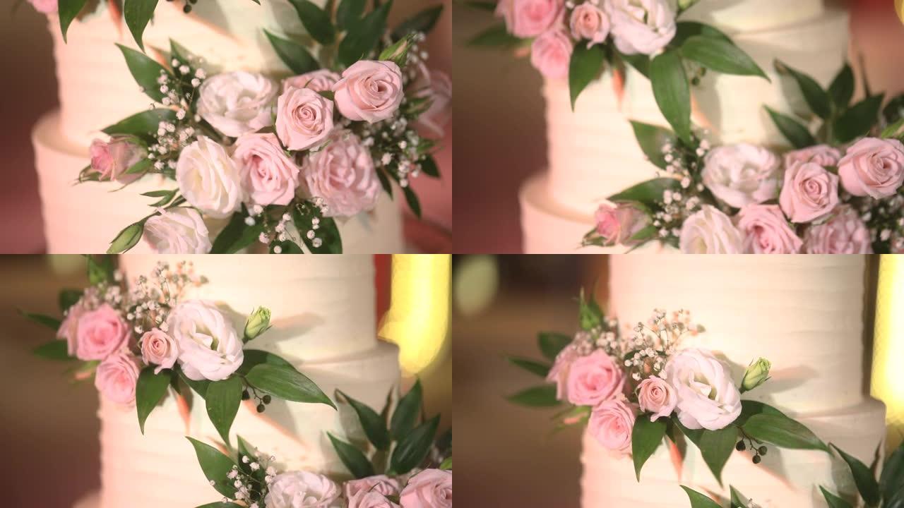美丽的婚礼蛋糕装饰着鲜花和白色和粉红色的色调。