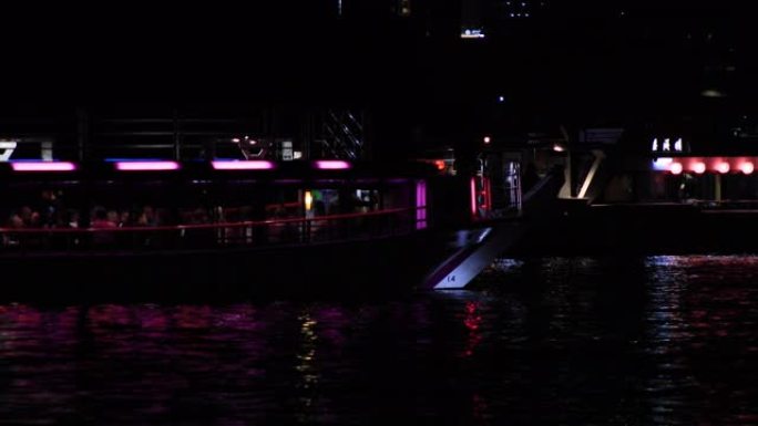 夜间在东京市区的海湾地区移动霓虹灯船