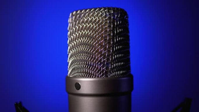 Studio Condenser Microphone Rotates on Blue Backgr