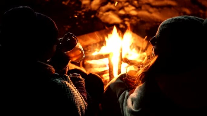 露营的朋友喝杯茶。概念。篝火。冬季时间