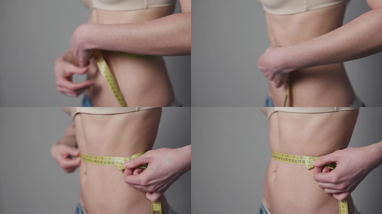 女人用磁带控制自己的措施。女人测量她的身体。减肥概念