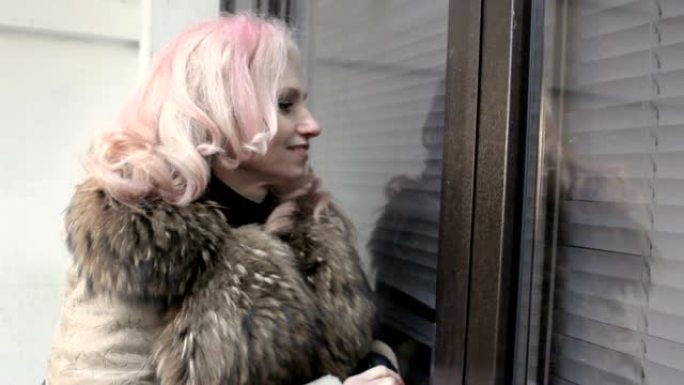 一个长着粉红头发的成年女子，正看着窗外