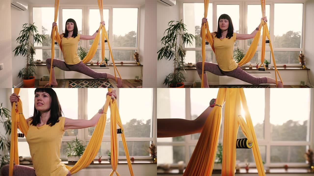飞行瑜伽。女人在公寓的吊床上做瑜伽练习。