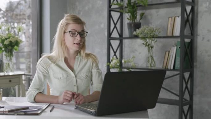 成功的商业，一位年轻的女企业家使用现代技术进行视频交流，一位女性在花卉内部使用在线交流与合作伙伴进行