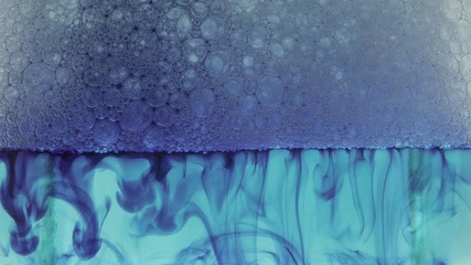 彩色肥皂泡沫与爆裂气泡背景。摘要生物结构，大分子模式。蓝色墨水填充了在液体中形成的大量白色气泡。自然