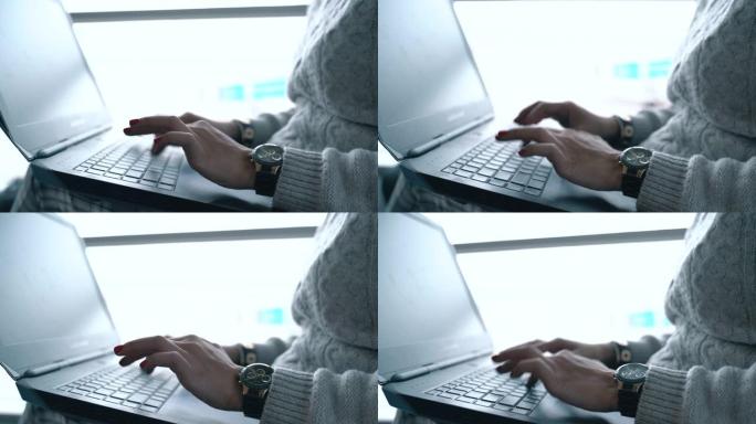 女人在机场手工打字笔记本电脑键盘