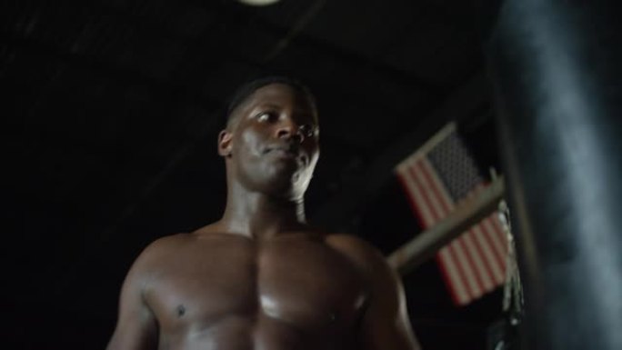 光着膀子的非裔美国人在MMA健身房完成了沉重的背包