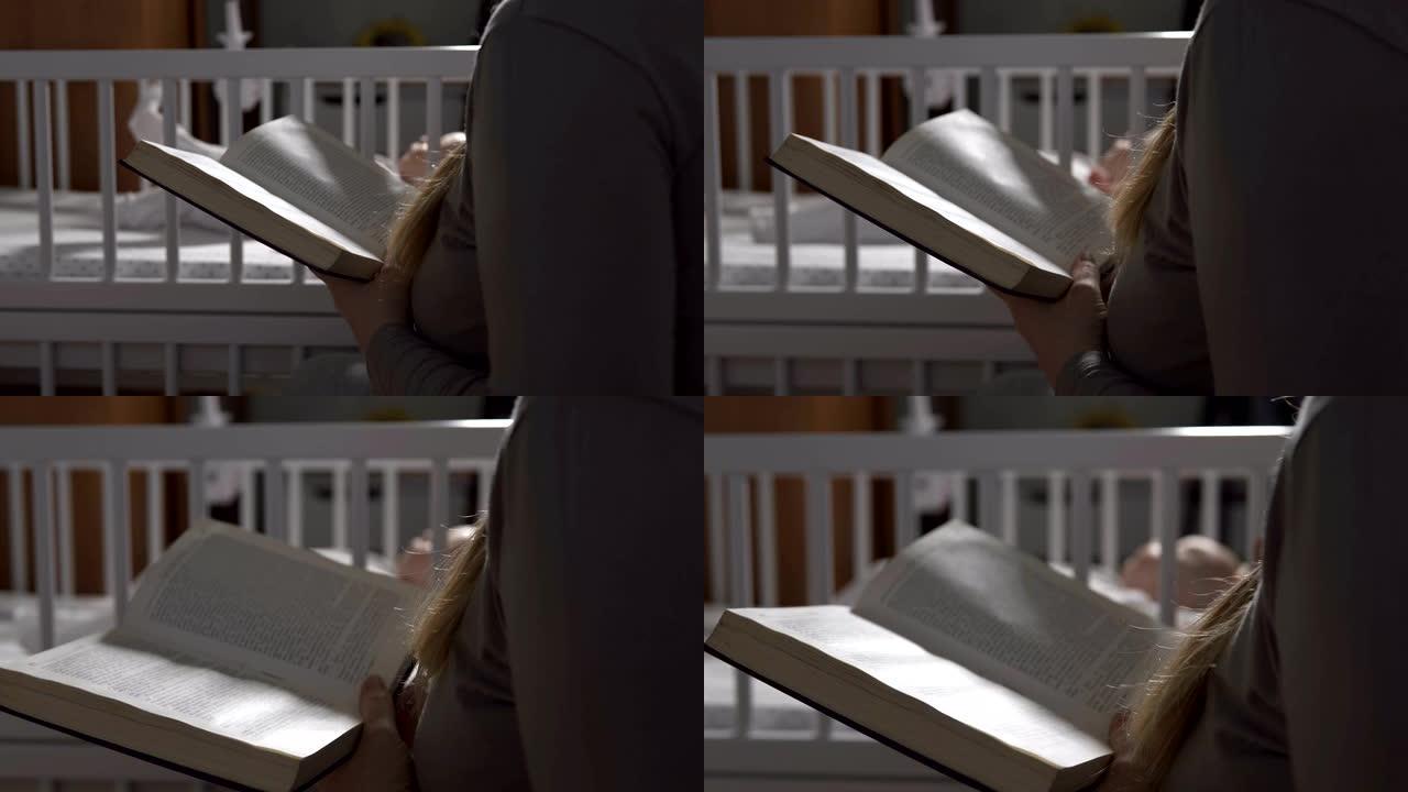 年轻的母亲在婴儿床上睡觉的婴儿旁边看书。母性的概念。