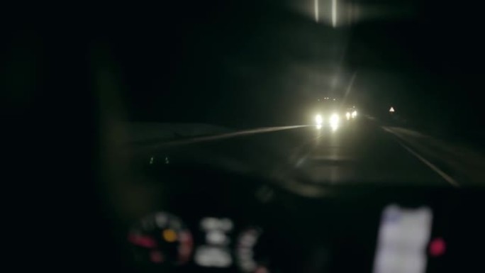 从车内拍摄的视频。司机在冬天晚上开车。迎面而来的汽车照亮了前灯。开车旅行。冬季的公路旅行。慢速mo