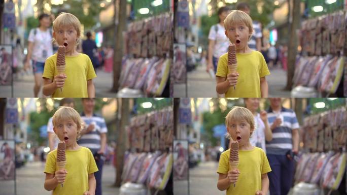 小男孩参观传统的韩国街头市场。男孩正在吃33厘米长的冰激丸。去韩国旅游概念。慢动作镜头