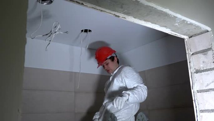 电动安装用天花板石膏板上的人。