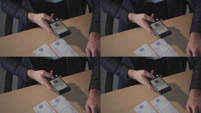 美国商人坐在办公室的桌子上输入密码的智能手机