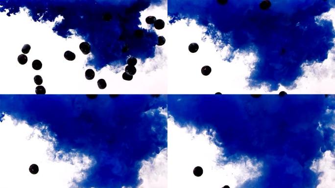 彩色蓝色墨水，在水中扩散并掉落蓝莓/彩色烟雾，以慢动作从上到下擦拭框架。孤立在黑色背景上。特写视图。