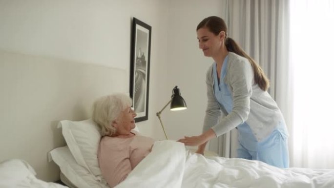 护理人员调整老年患者的毯子