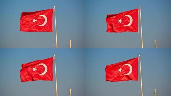 土耳其国旗站在金属柱上，在强烈的夏风中挥舞。