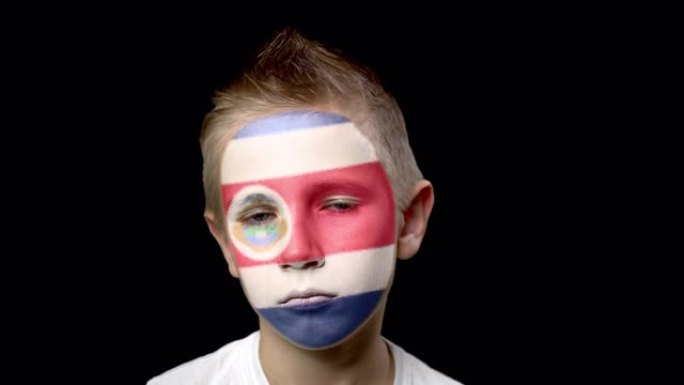 哥斯达黎加足球队的悲伤球迷。脸上涂着民族色彩的孩子。