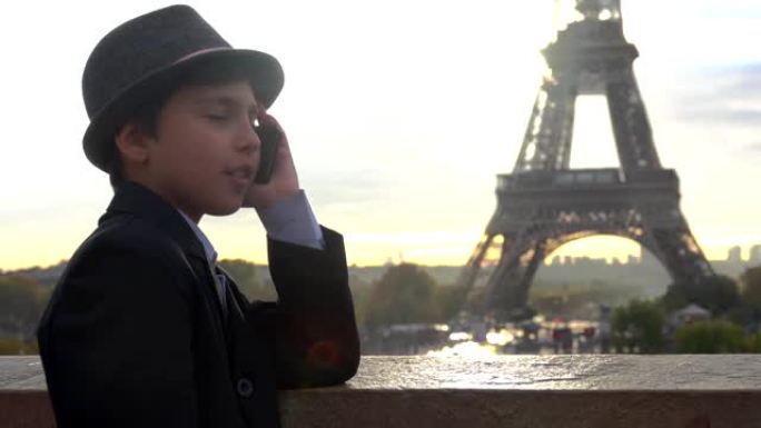 戴着帽子的帅哥正在电话里聊天，在埃菲尔铁塔上观看