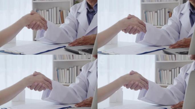 医生在办公室和病人握手。资深亚洲男女。