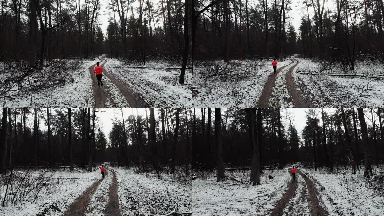 在公园跑步的女人。穿着橙色夹克的职业女运动员在冬季森林慢跑。越野跑概念