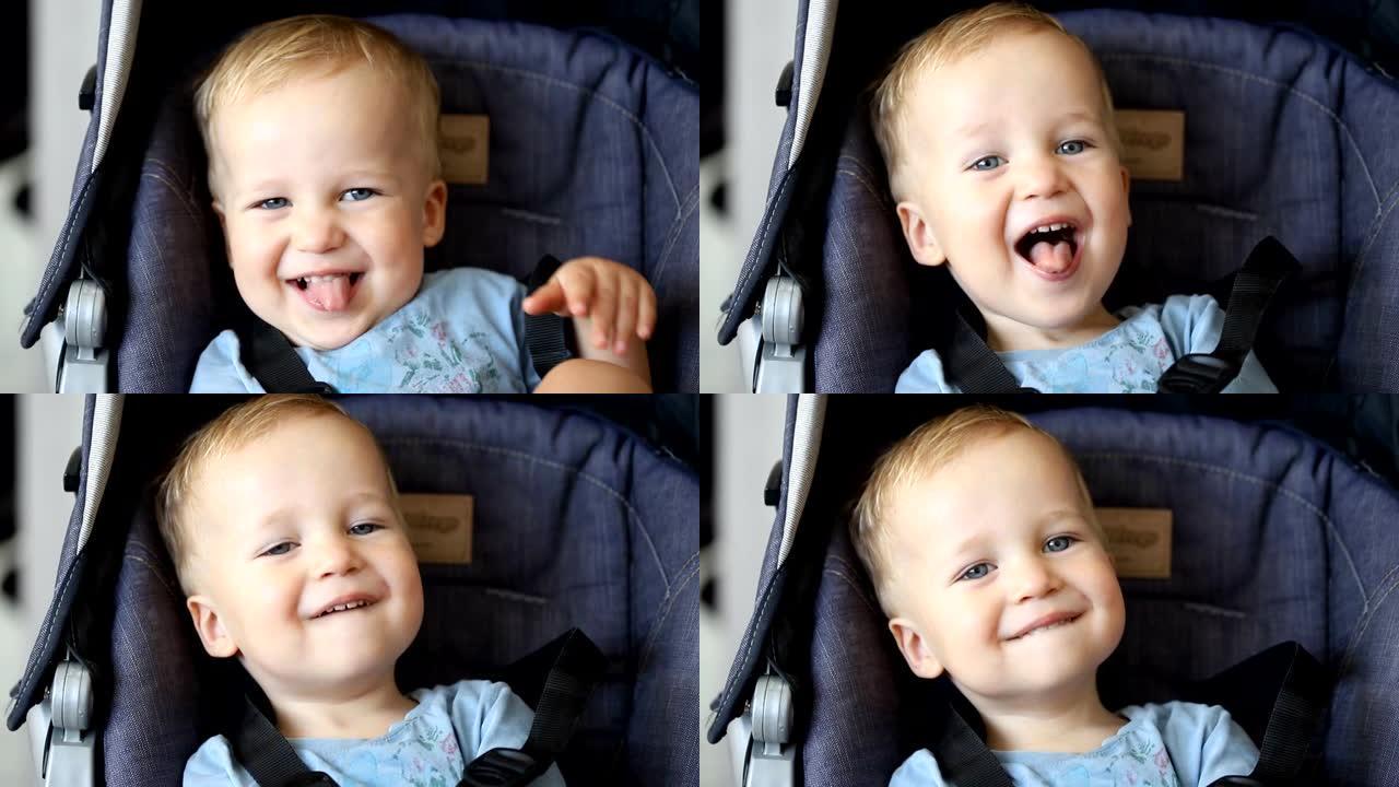 可爱的可爱的快乐高加索金发蹒跚学步的男孩坐在婴儿车里笑着玩寻找和隐藏游戏。