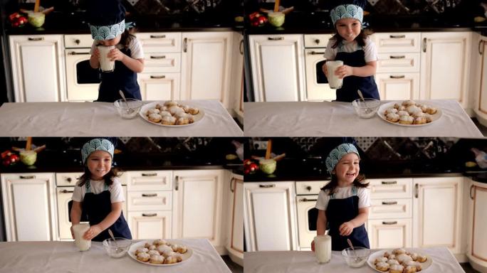 一个小女孩喝牛奶或开菲尔，在厨房里吃饼干。