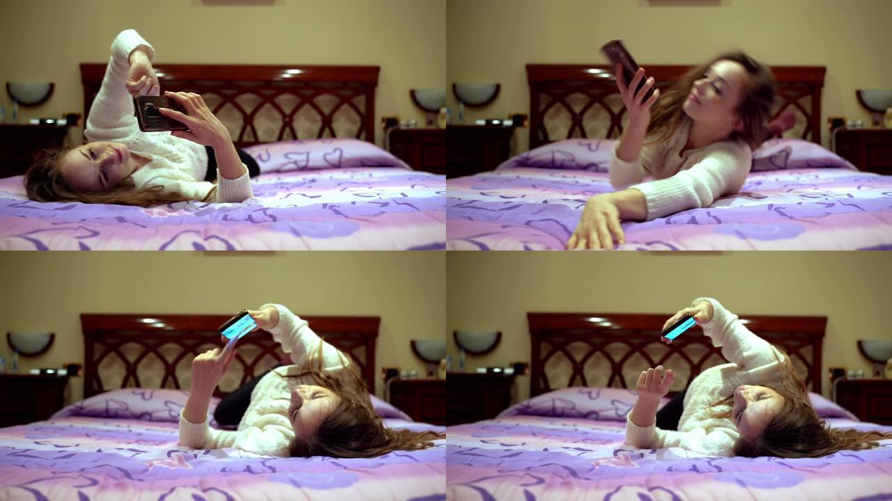年轻女孩在家放松，躺在床上，使用智能手机。女孩从左到右转向，在线浏览，阅读社交网络并使用移动应用程序