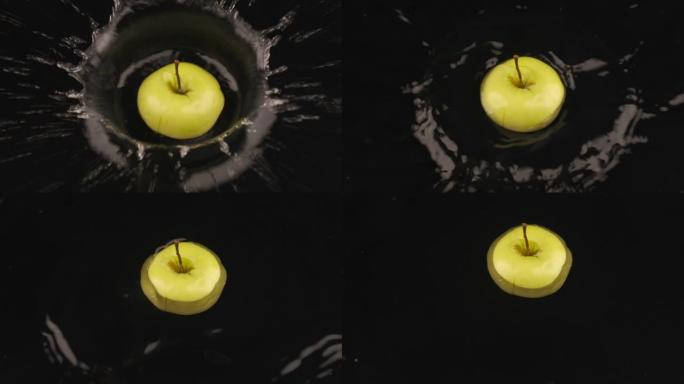 成熟多汁的苹果片落在覆盖着水的黑色表面上。慢动作。水中的水果和美丽的水花。
