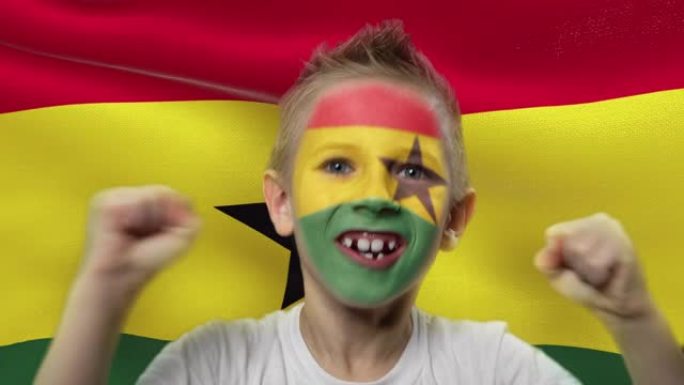 加纳国旗背景上的快乐粉丝。有着民族色彩的脸的快乐男孩。