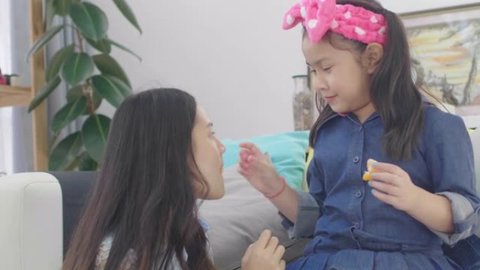 亚洲女孩剥橙，用幸福的脸喂姐姐。