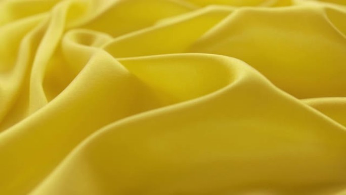 旋转黄色缎子褶皱纹理静物拍摄广告素材