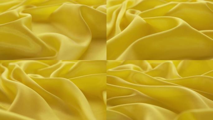 旋转黄色缎子褶皱纹理静物拍摄广告素材