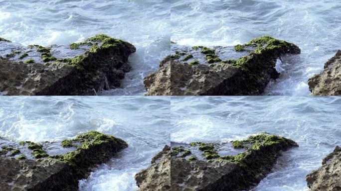 小浪撞击并溅到海边。行动。海浪撞击岩石。小石头上的海浪飞溅