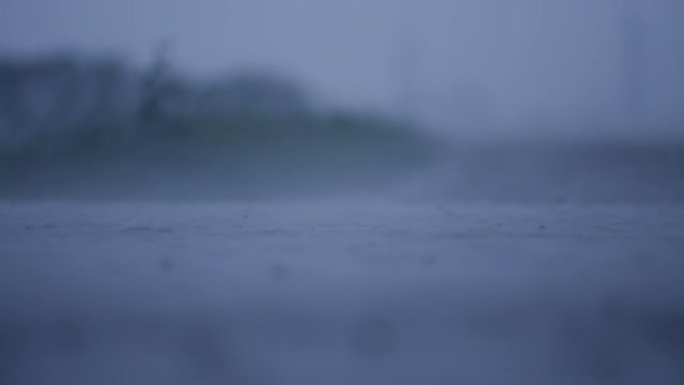 在热带风暴造成洪水的过程中，缓慢的雨滴溅到水坑中。