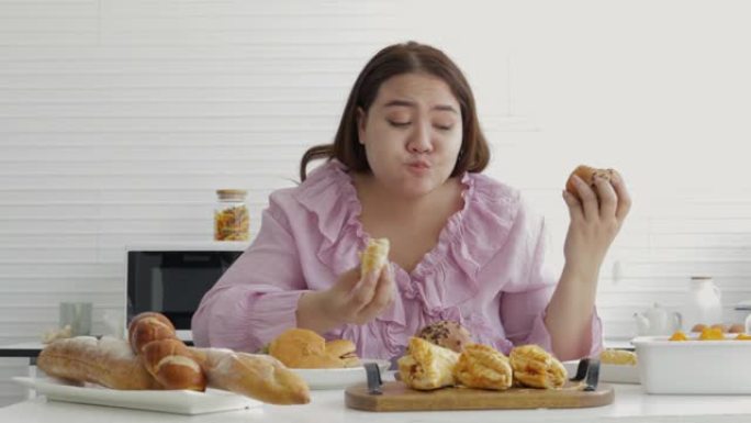胖女孩疯狂美味地吃垃圾食品。有法式面包，白面包，小麦面包，全麦面包，汉堡面包和羊角面包。垃圾食品和超
