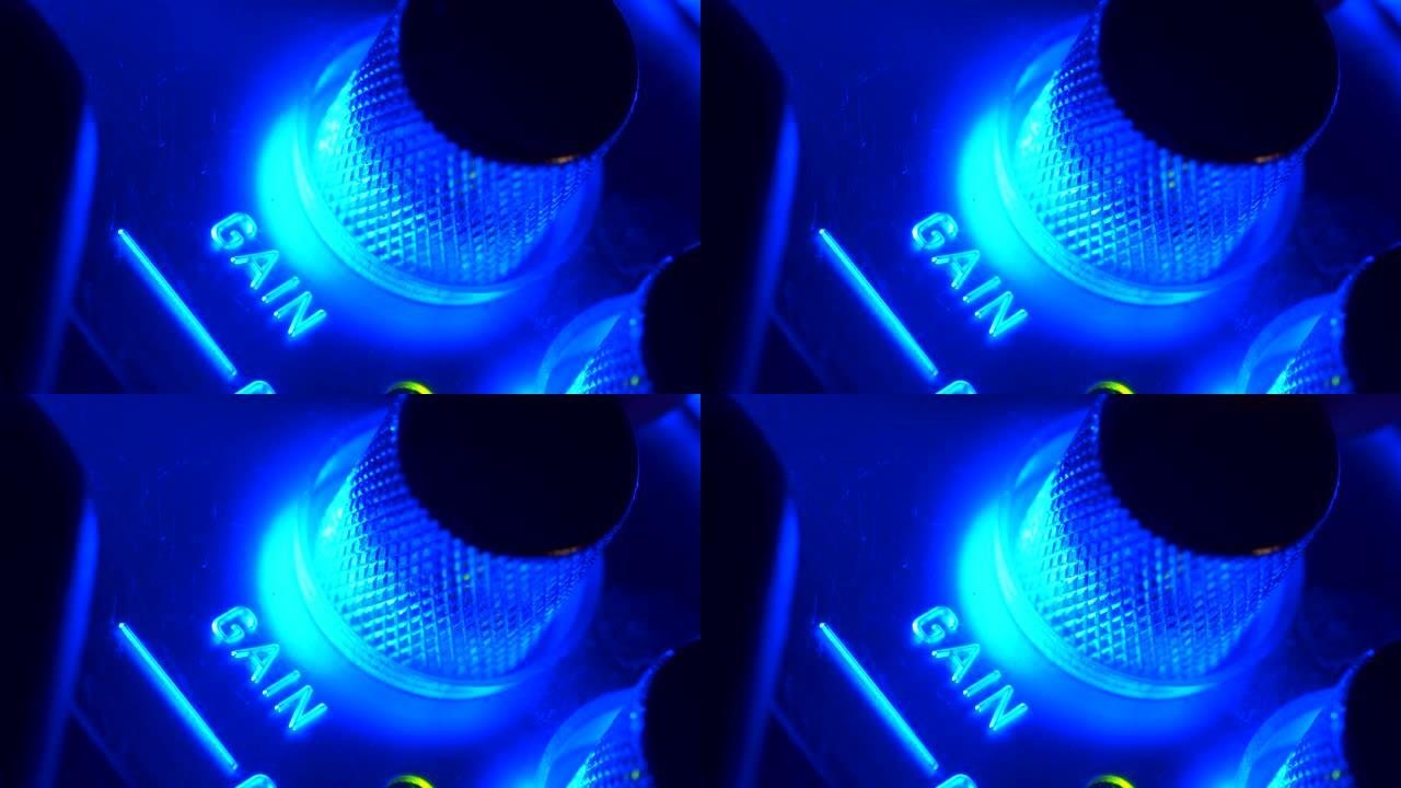 带有蓝光闪烁的放大器声音上控制面板的特写转向按钮增益