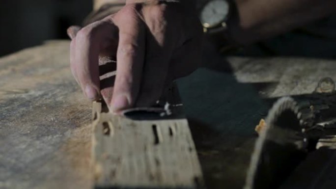 工匠用砂纸手工打磨一块木头