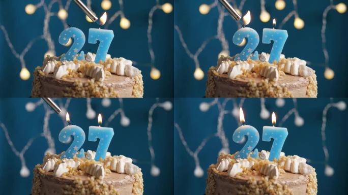 蓝色背景上有27个数字蜡烛的生日蛋糕。蜡烛着火了。慢动作和特写视图