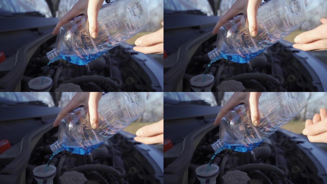 女人用整瓶防冻液用刮水器液手工填充汽车储液罐