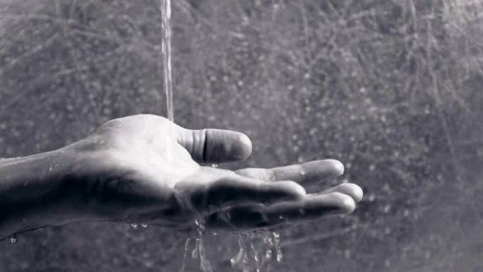 水从男人的手中倾泻而出。人类正试图把水放在手掌里。时间概念。