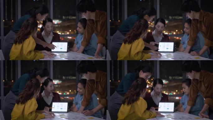 亚洲女性领导者建议ux/ui设计师关于夜间现代办公室餐桌上的移动应用界面线框设计。工作后期创意数字开