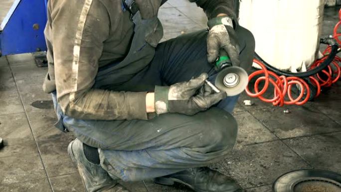 汽车机械用电动磨床工具在提升汽车附近抛光生锈的螺栓