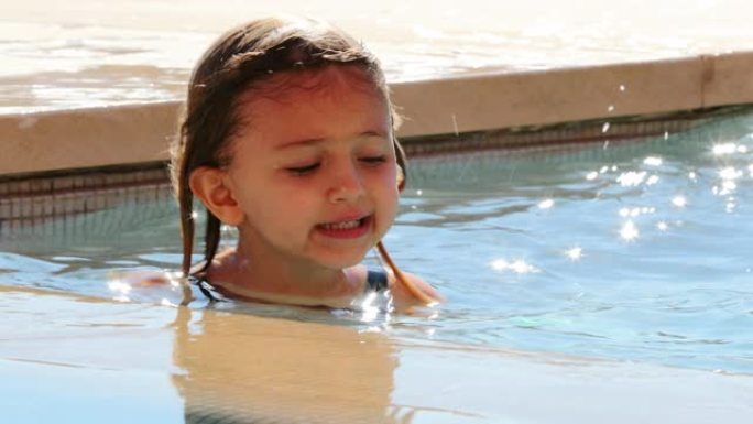 游泳池里的小女孩肖像微笑着独自自言自语