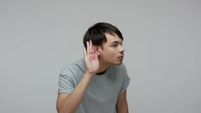 有听力问题的年轻人把手放在耳朵附近，仔细聆听，专注于声音