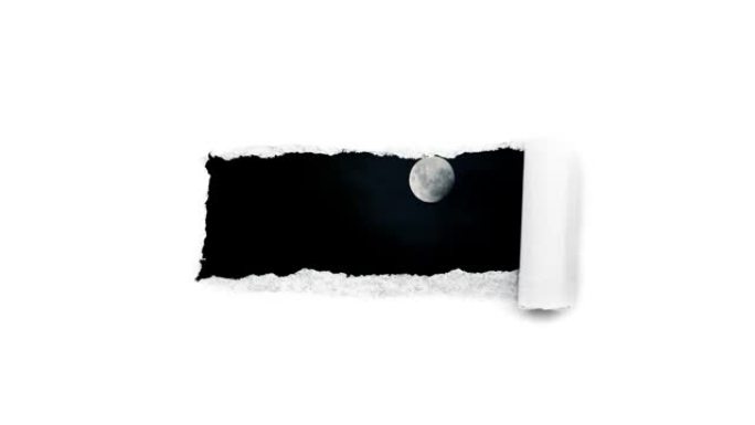 创意4k时间圈视频，在夜空中有浮云的发光满月，通过白纸边缘撕裂的孔可以看到。