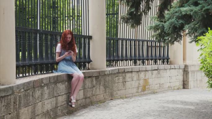 姜红发女孩看着智能手机。
