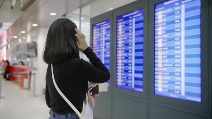 女乘客在离境机场登机前在离境登机前检查她的航班。