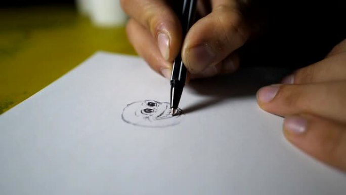男性的特写手握着圆珠笔，在白纸上画笑脸。才华横溢的艺术家在素描本中描绘美丽的小图像。艺术和创造力概念